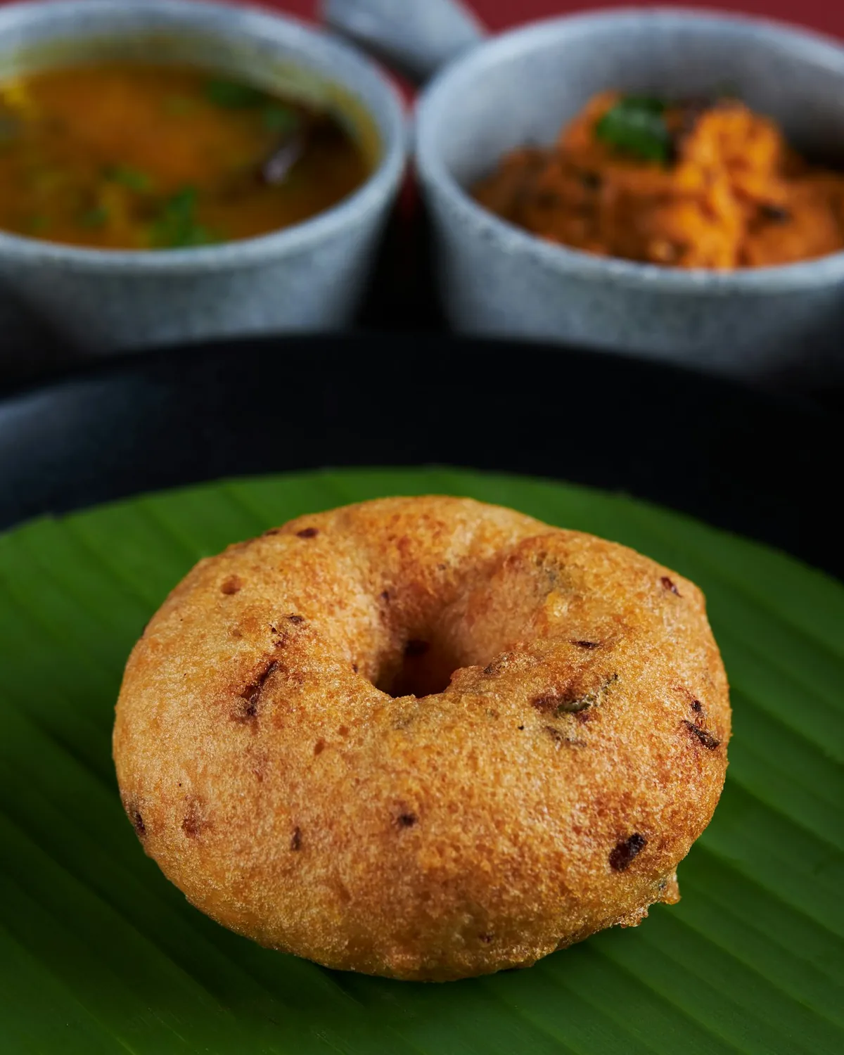 A crisp medu vada on a banana leaf, with sambar and chutney